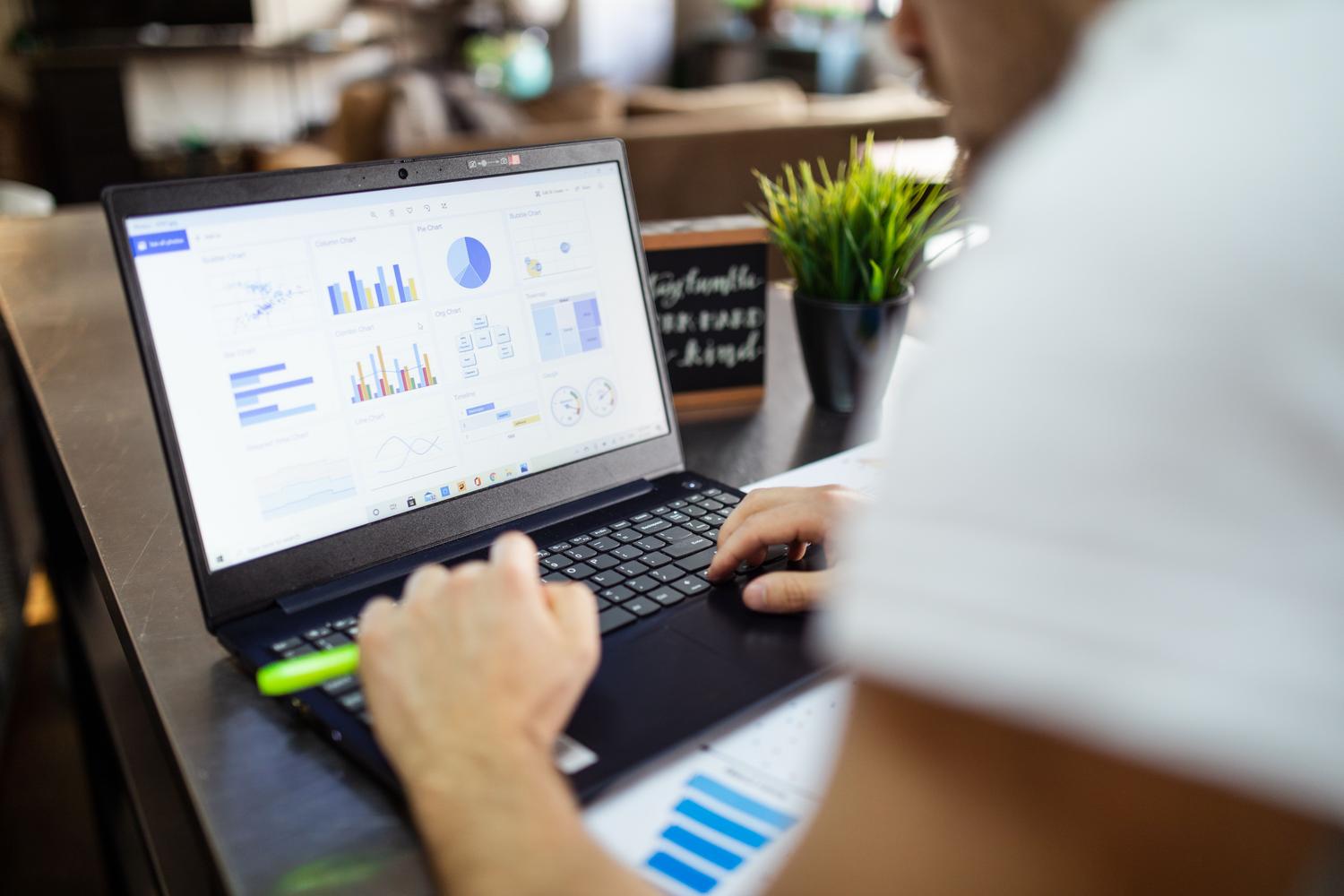 Análisis de datos empresariales con gráficos y tablas en la pantalla de un portátil en un entorno corporativo.