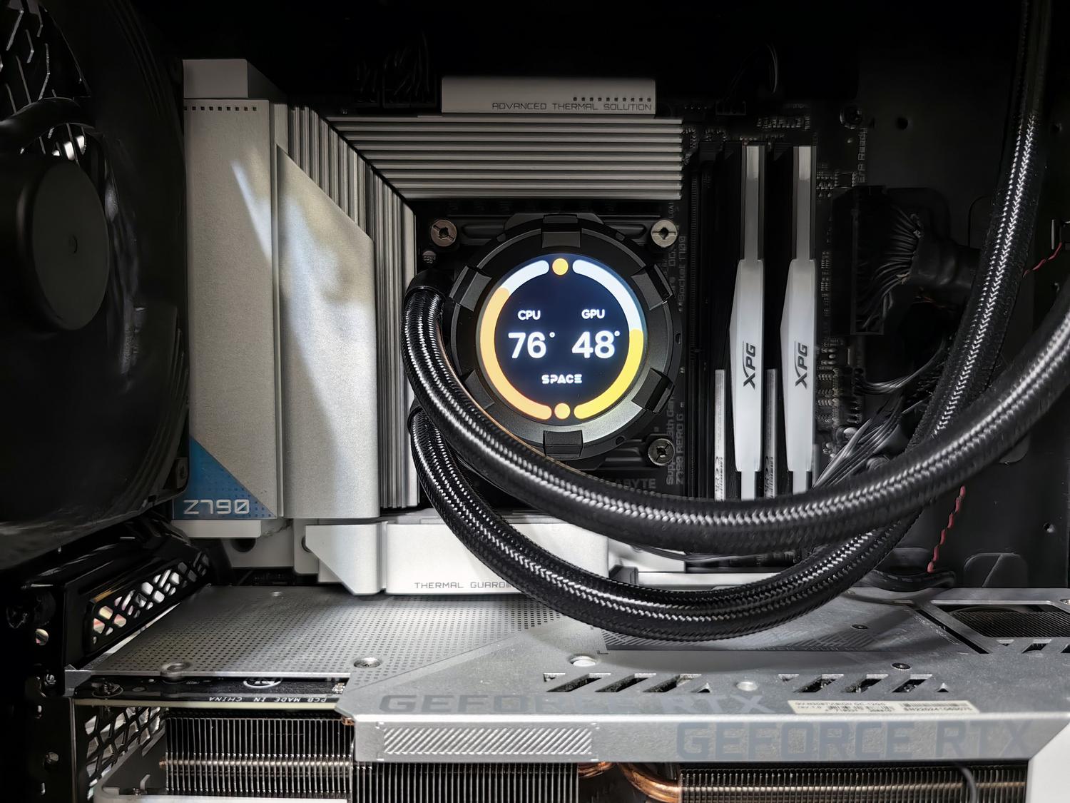 Interior de un ordenador de alto rendimiento con pantalla integrada que muestra la temperatura de la CPU y la GPU.