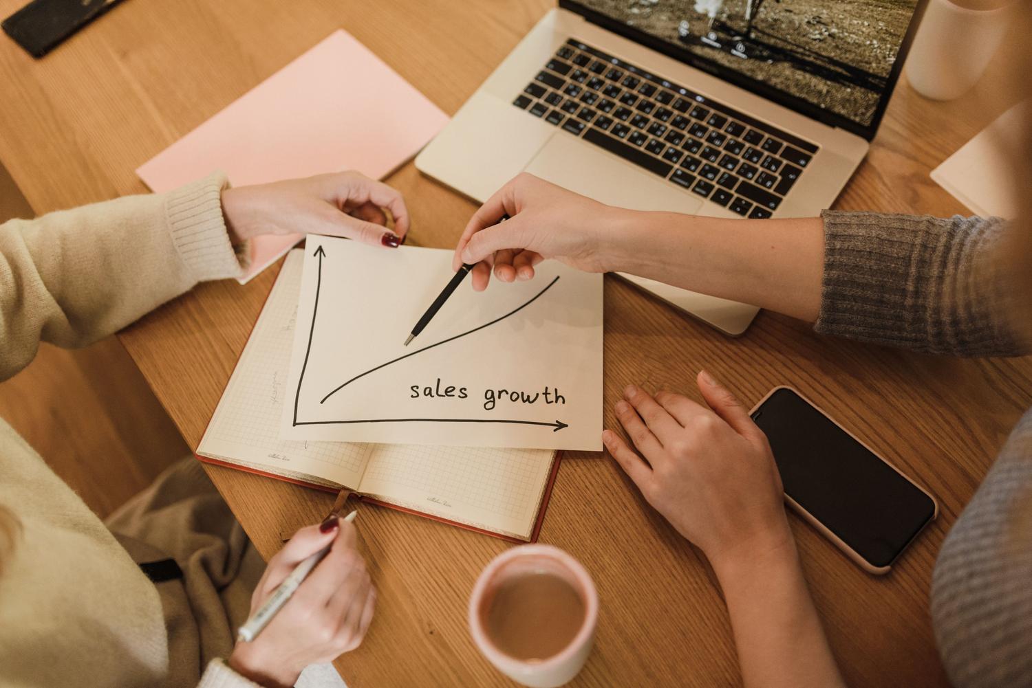 Profesionales analizando gráficas de crecimiento de ventas para optimizar la estrategia de marketing y ventas.
