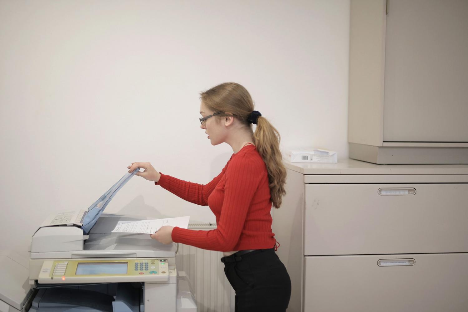 Büroangestellter bedient ein professionelles Multifunktionsgerät zur Dokumentenverwaltung.