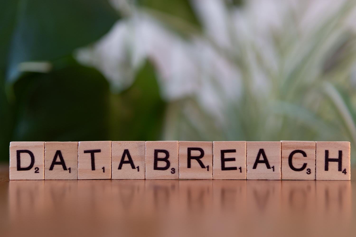 Letras de madera formando la frase 'data breach' para representar visualmente una brecha de datos y su impacto.