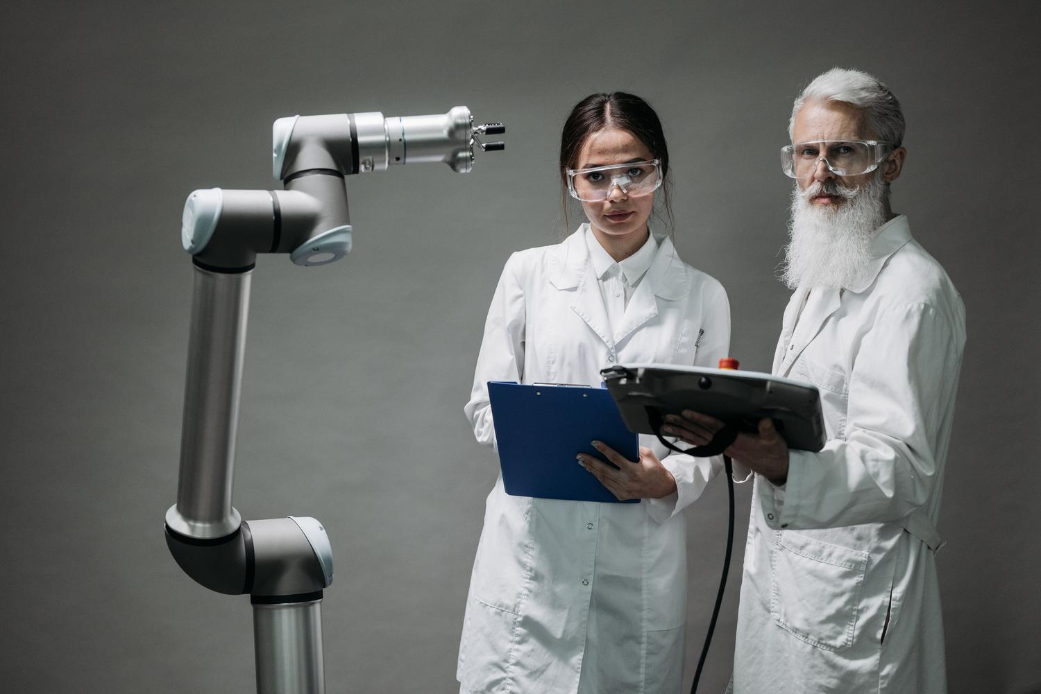 Científicos analizando el funcionamiento de un brazo robótico en un laboratorio médico, representando los avances en salud y medicina.